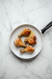 This image shows the cooked chicken being removed from the skillet and set aside.