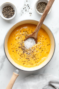 This image shows spices being added to the cheese sauce for seasoning.