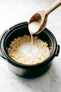 whisking-the-evaporated-milk-and-eggs-and-adding-to-macaroni to make it creamier and richer in taste