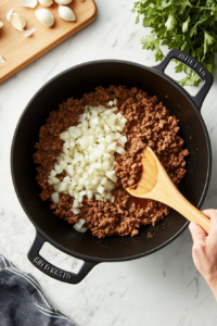 This image shows diced onion and minced garlic added to the pot