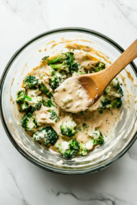 This image shows Alfredo sauce being mixed into the chicken and broccoli mixture, creating a creamy and flavorful filling.