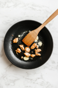 This image shows oil and butter melting in a skillet, ready for cooking the marinated chicken to create a rich and savory dish.