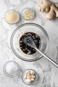This image shows a glossy teriyaki sauce being stirred in a saucepan, blending soy sauce, ginger, garlic, and other ingredients for a rich, flavorful glaze.