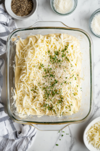 sprinkling-shredded-mozzarella-cheese-and-italian-seasonings-over-the-dough