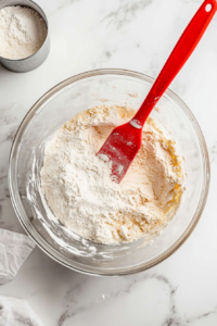 This image shows butter, sugar, and flour being blended together to form a crumbly topping that will add a sweet crunch to the bread.