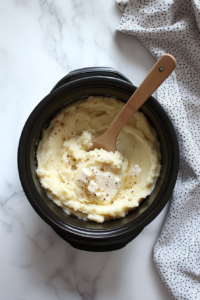 This image shows butter, cream cheese, and milk being added to the mashed potatoes, making them extra creamy and indulgent.