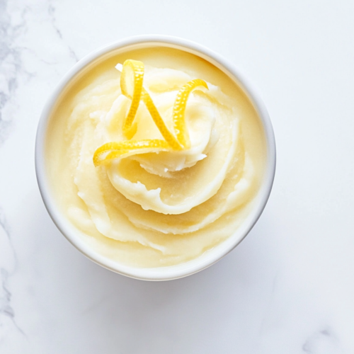 creamy-lemon-sorbet-in-round-white-bowl-with-bright-yellow-zest-on-top-for-fresh-summer-dessert