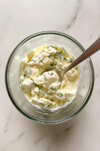This image shows sour cream and condensed soup being mixed together into a smooth, creamy base to bring richness to the casserole.