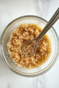 This image shows flour, baking soda, and salt being whisked together in a mixing bowl to prepare the dry cake ingredients.