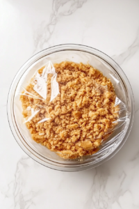 This image shows the crumble mixture being placed into the refrigerator to chill while the cake batter is prepared.