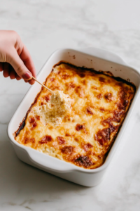 inserting-a-toothpick-into-the-baked-dish-to-check-for-doneness-7266206-683x1024