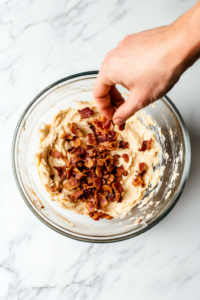 sprinkling-crispy-crumbled-bacon-into-the-mixture-6921805-683x1024