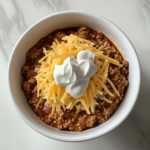 homemade-chili-in-black-dutch-oven-on-white-marble-countertop