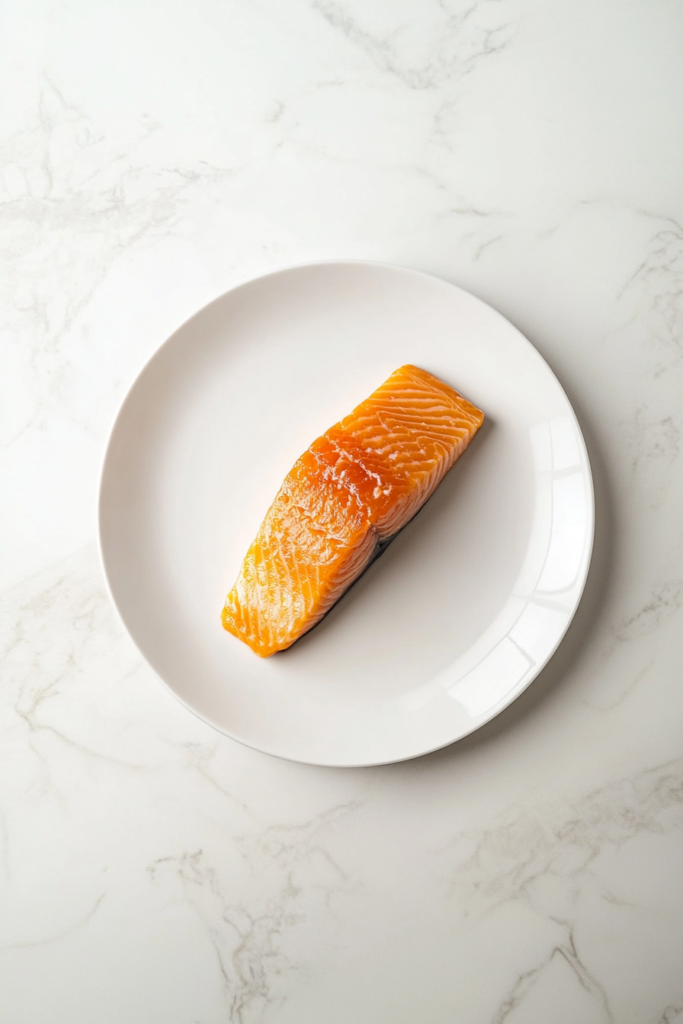 This image shows freshly smoked salmon fillets resting on a stainless steel wire rack over a baking sheet on a white marble countertop before refrigeration.