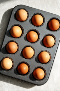 eggs-in-muffin-tin-ready-for-baking-on-white-marble