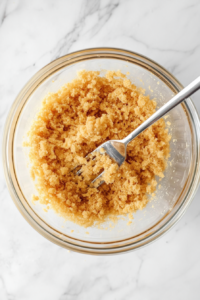 melted-butter-graham-cracker-mix-in-glass-bowl-for-banana-split-cake