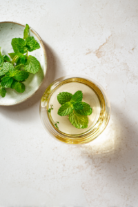 muddle-stgermain-and-mint-in-clear-glass-over-marble